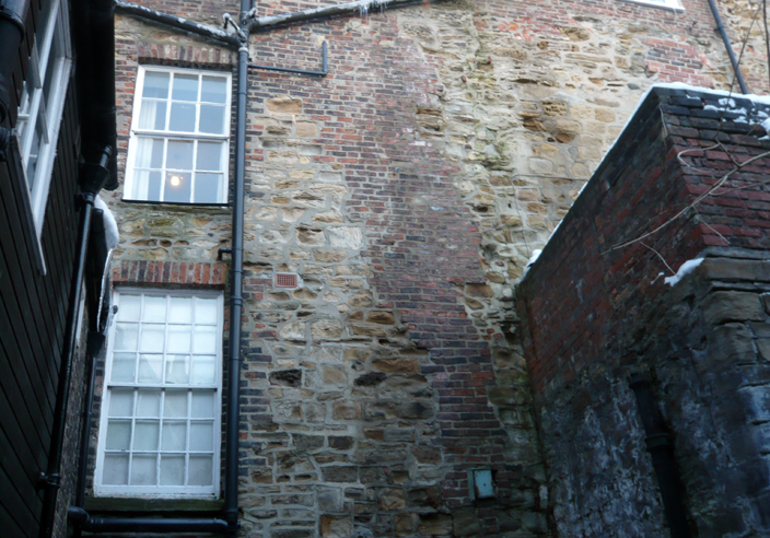 This image shows the back of a building on Owengate that was built along the line of the Castle walls and incorporates their remains in its construction. All the stonework is medieval, while the brickwork is from around 1800.